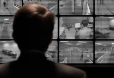 19882888 - man watching an employee work via a closed-circuit video monitor