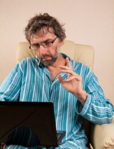 15127555 - mature man sitting in chair with laptop