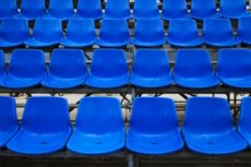 Empty plastic seats at stadium, open door sports arena