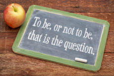 35846309 - to be, or not be, that is the question - text on a slate blackboard against red barn wood